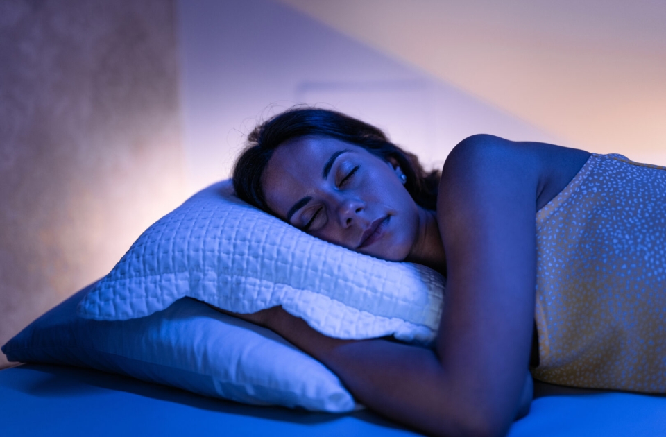 Adult woman, soundly sleeping in her comfortable bed, at home.